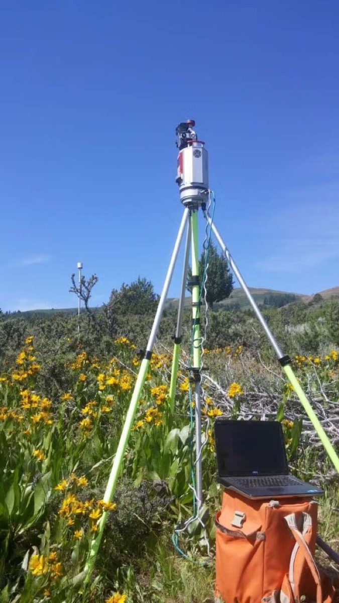 Riegl VZ-1000 terrestrial laser scanner on a tripod in a field with laptop control station